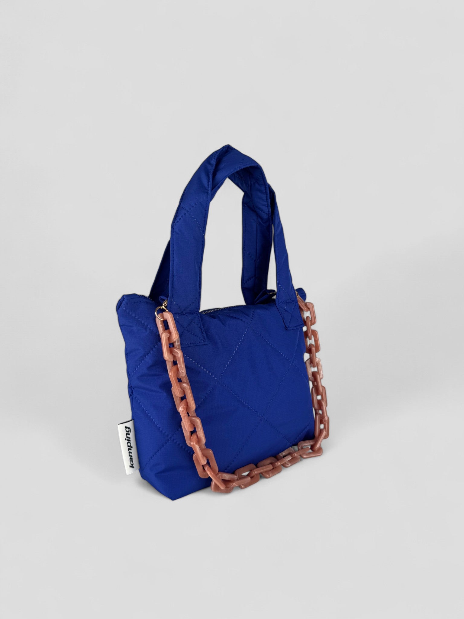 Kamping Studios, kleine Umhängetasche in Blau, Produktfoto, Seitenansicht mit rosa Kette