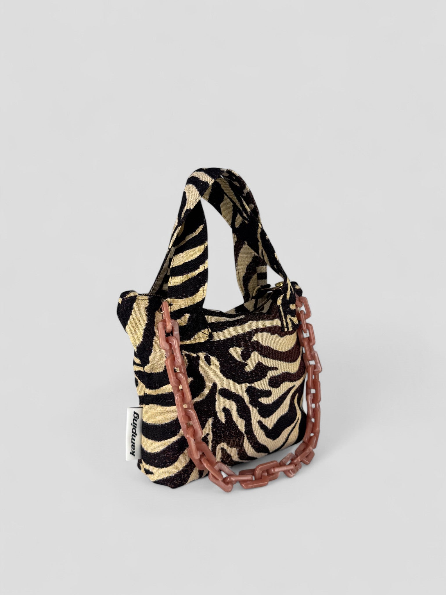 Kamping Studios kleine Umhängetasche mit Zebra-Muster, Produktfoto, Vorderansicht mit rosa Kette