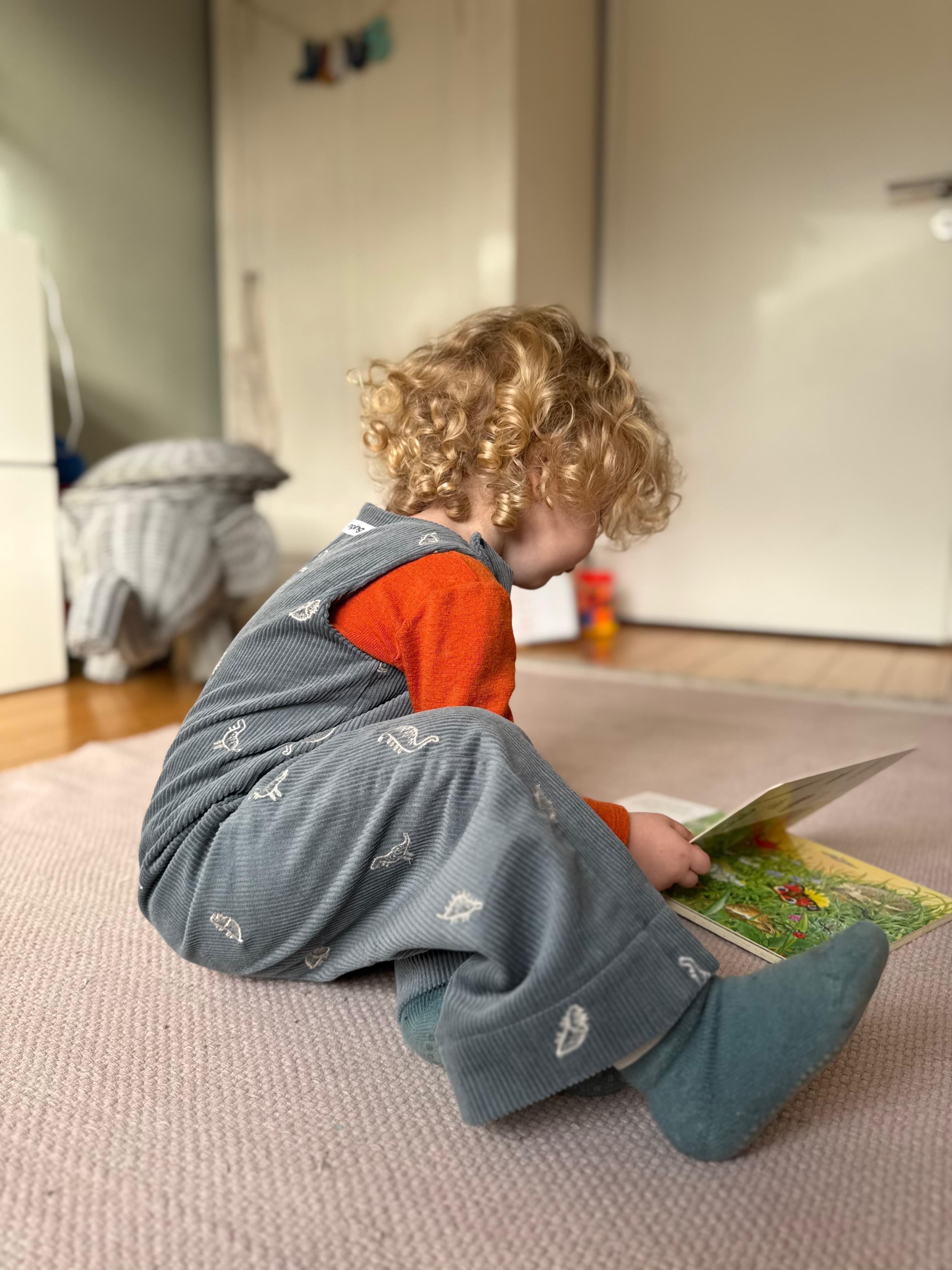 Kamping Studios Baby Overall und Strampler aus Cord mit Dinosauriern am Model, spielend Mood