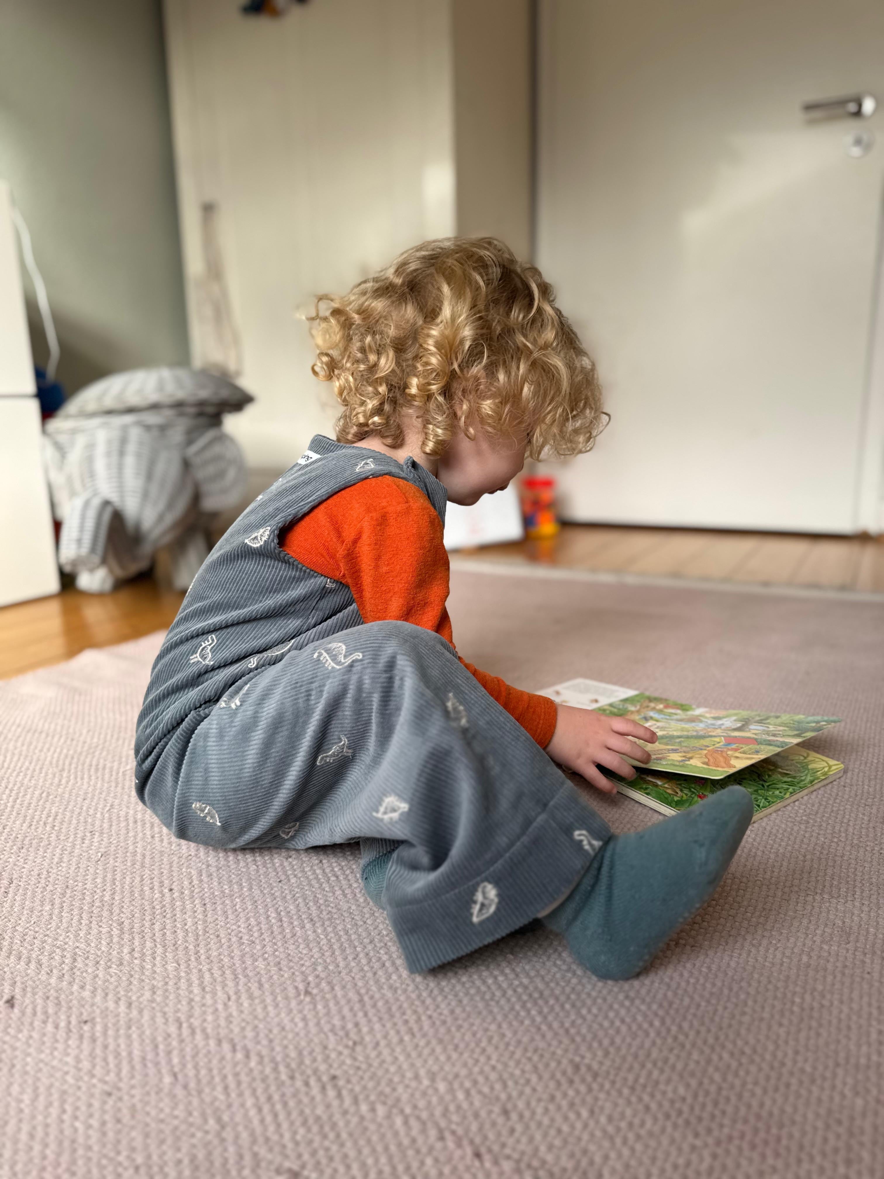 Kamping Studios Baby Overall und Strampler aus Cord mit Dinosauriern am Model, Seite