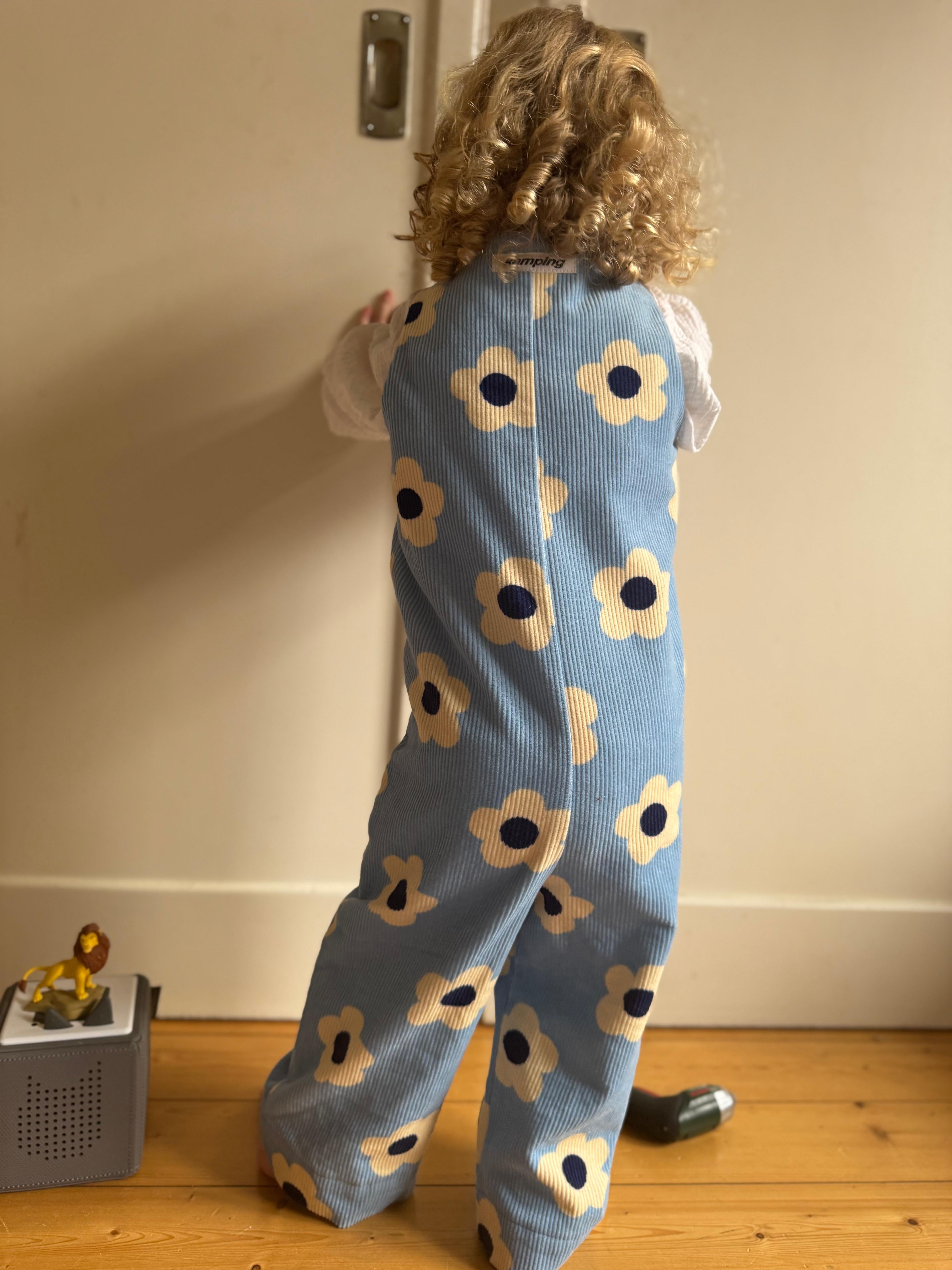 Kamping Studios - Baby Overall und Strampler mit blauen Blumen am Model, Rueckseite