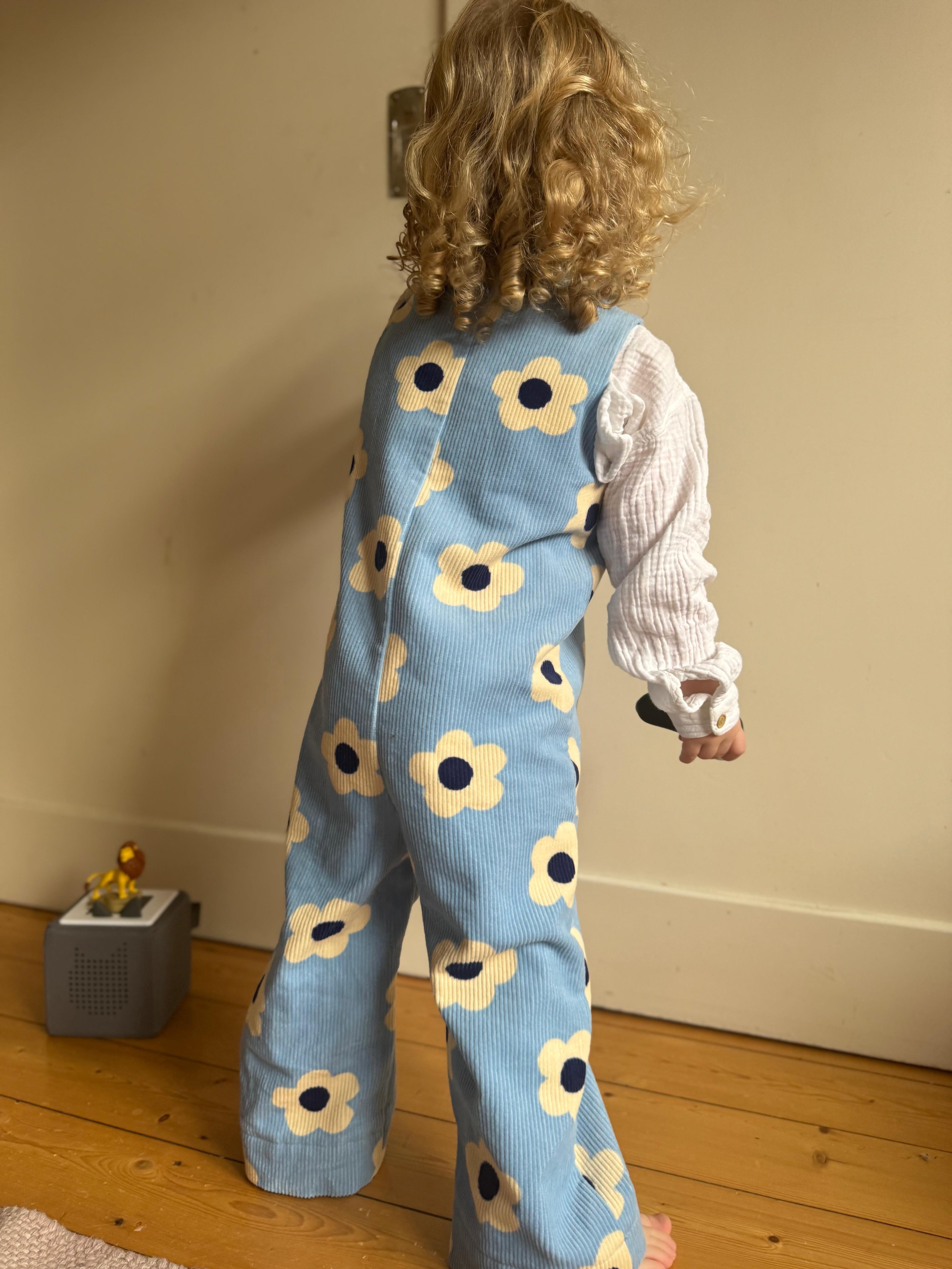 Kamping Studios - Baby Overall und Strampler mit blauen Blumen am Model, Rueckseite 4