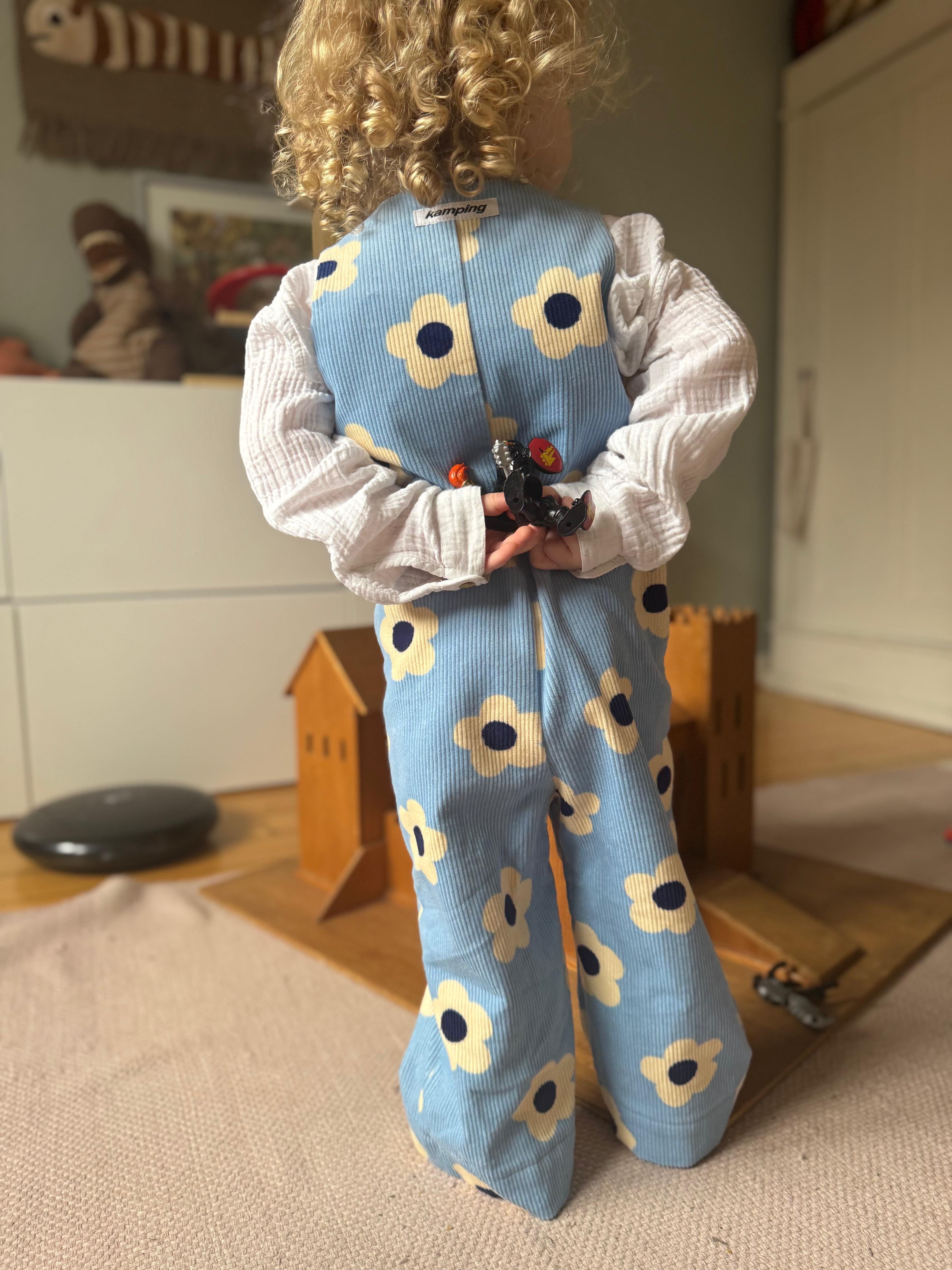 Kamping Studios - Baby Overall und Strampler mit blauen Blumen am Model, Rueckseite 3