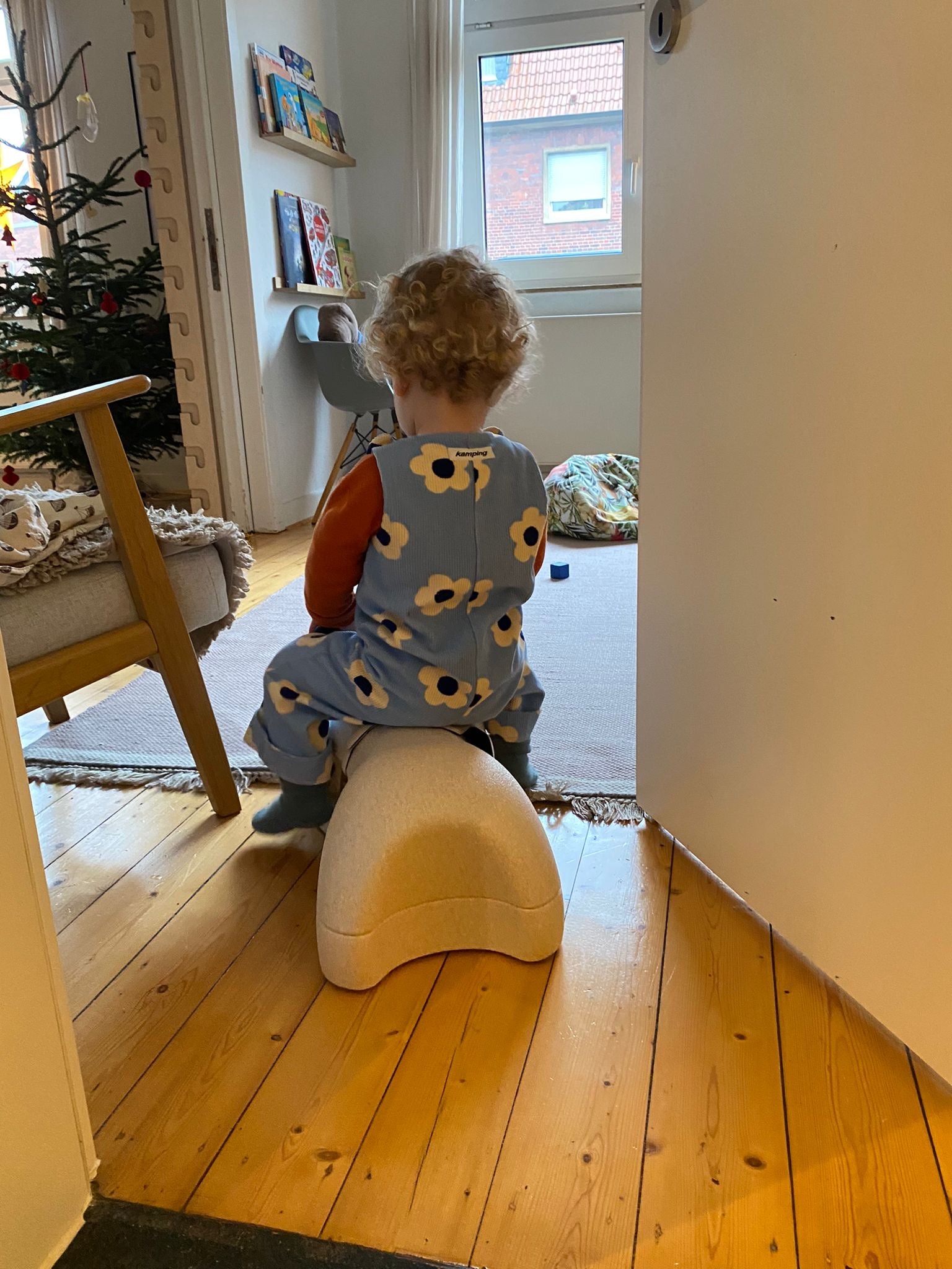 Kamping Studios - Baby Overall und Strampler mit blauen Blumen am Model, Rueckseite am spielend