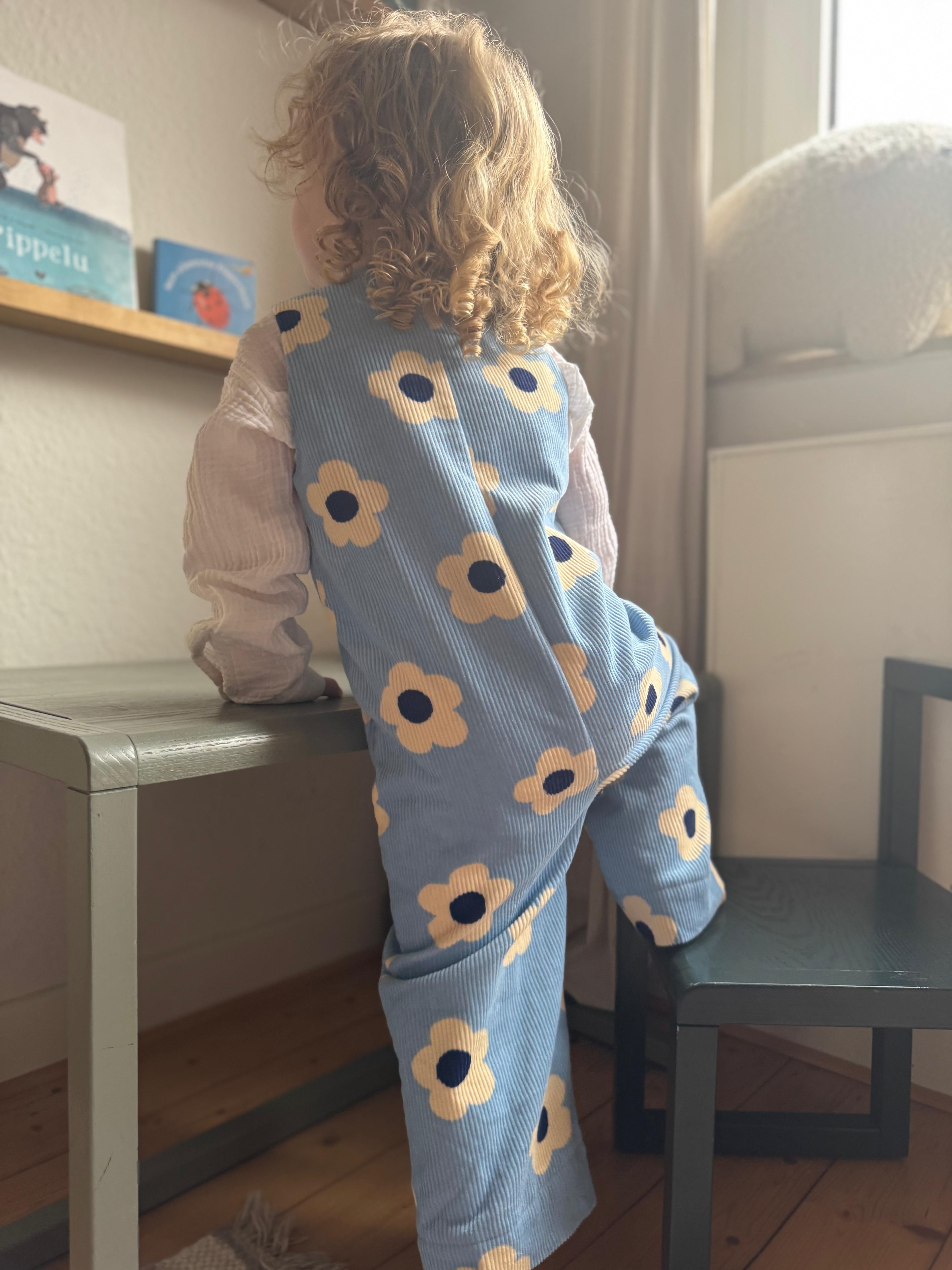 Kamping Studios - Baby Overall und Strampler mit blauen Blumen am Model, Rueckseite 2