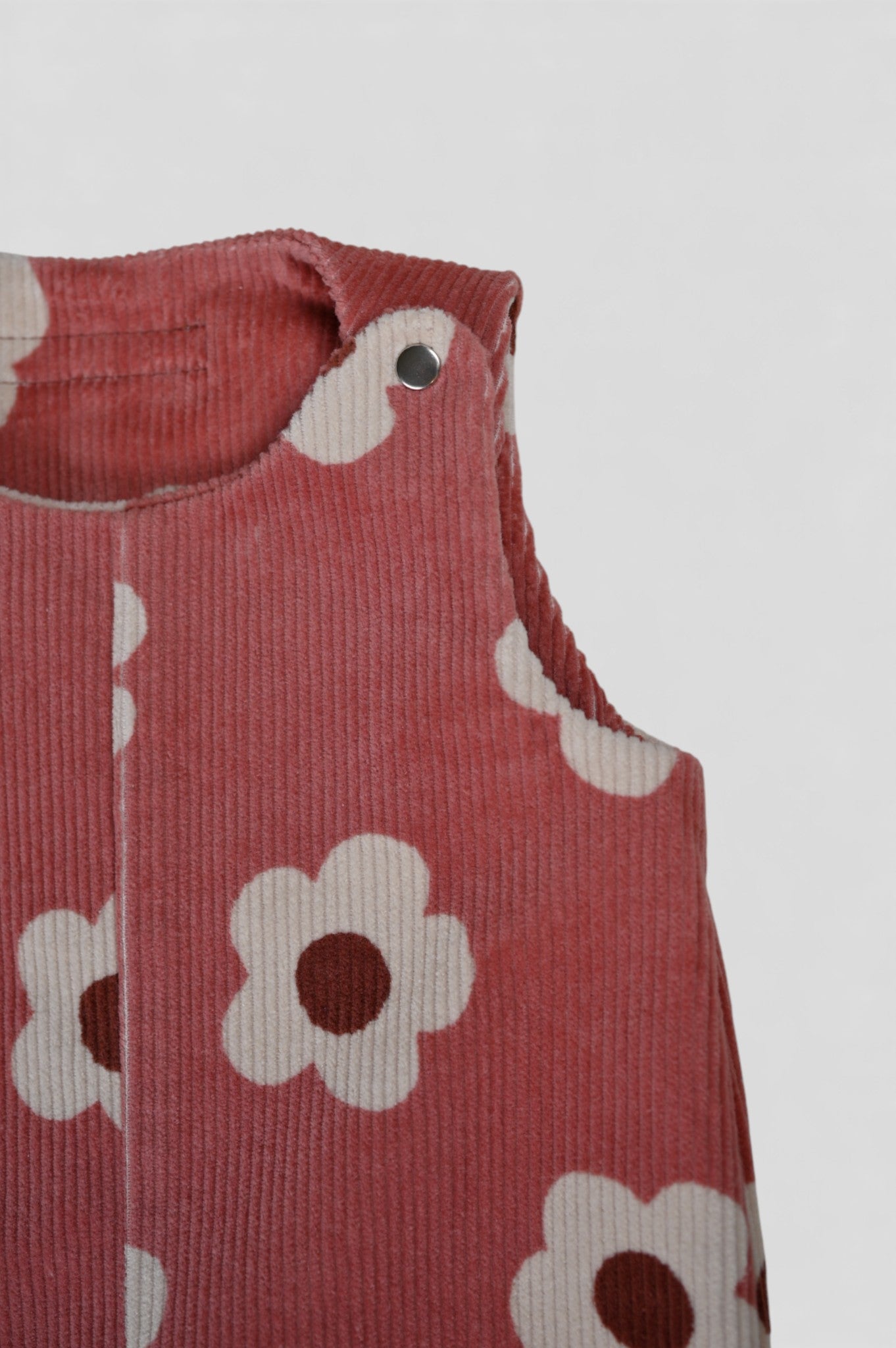 Baby Overall und Strampler mit rosa Blumen, Detail von Knopf