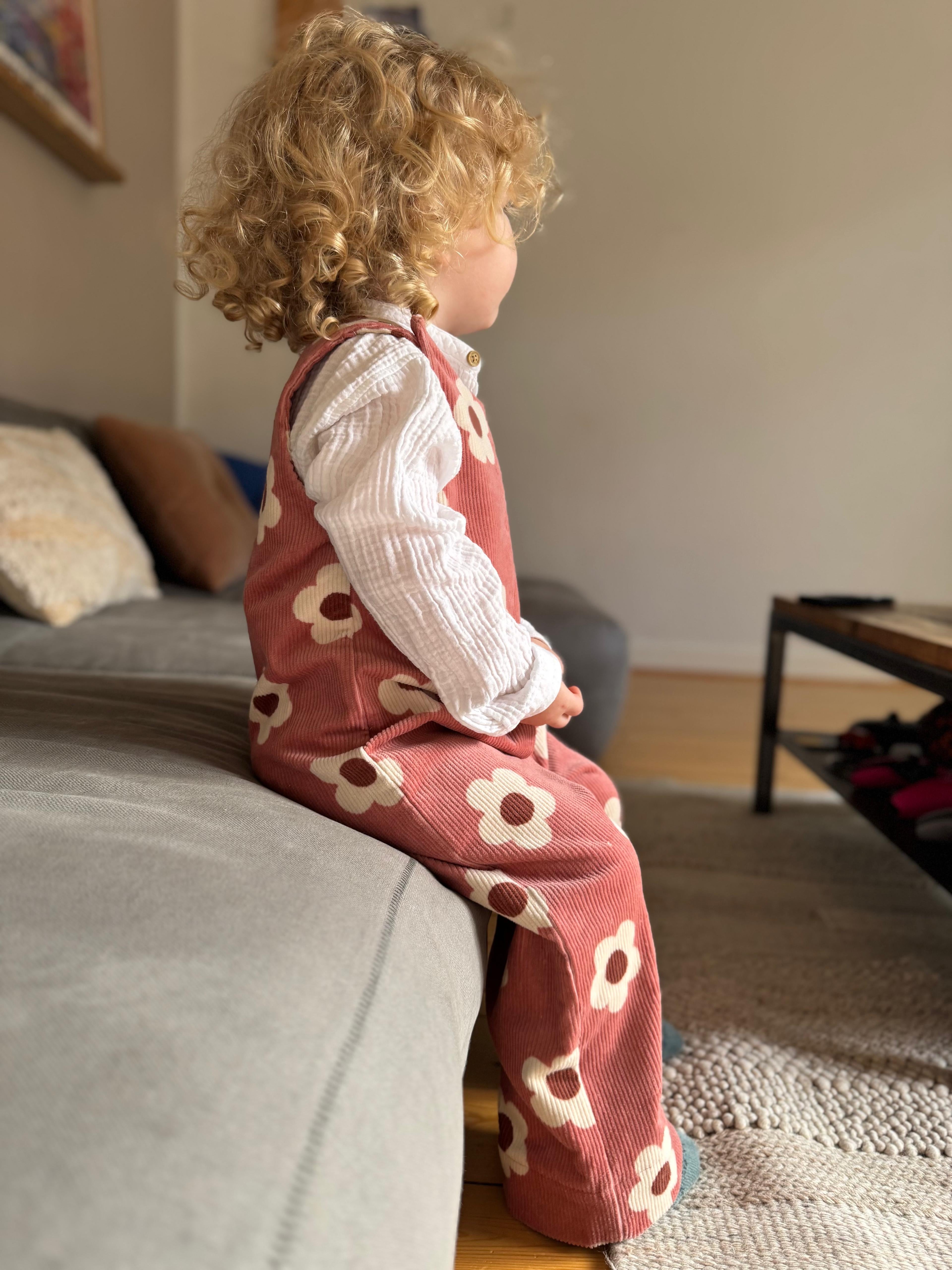 Baby Overall und Strampler mit rosa Blumen am Model, Seitenansicht
