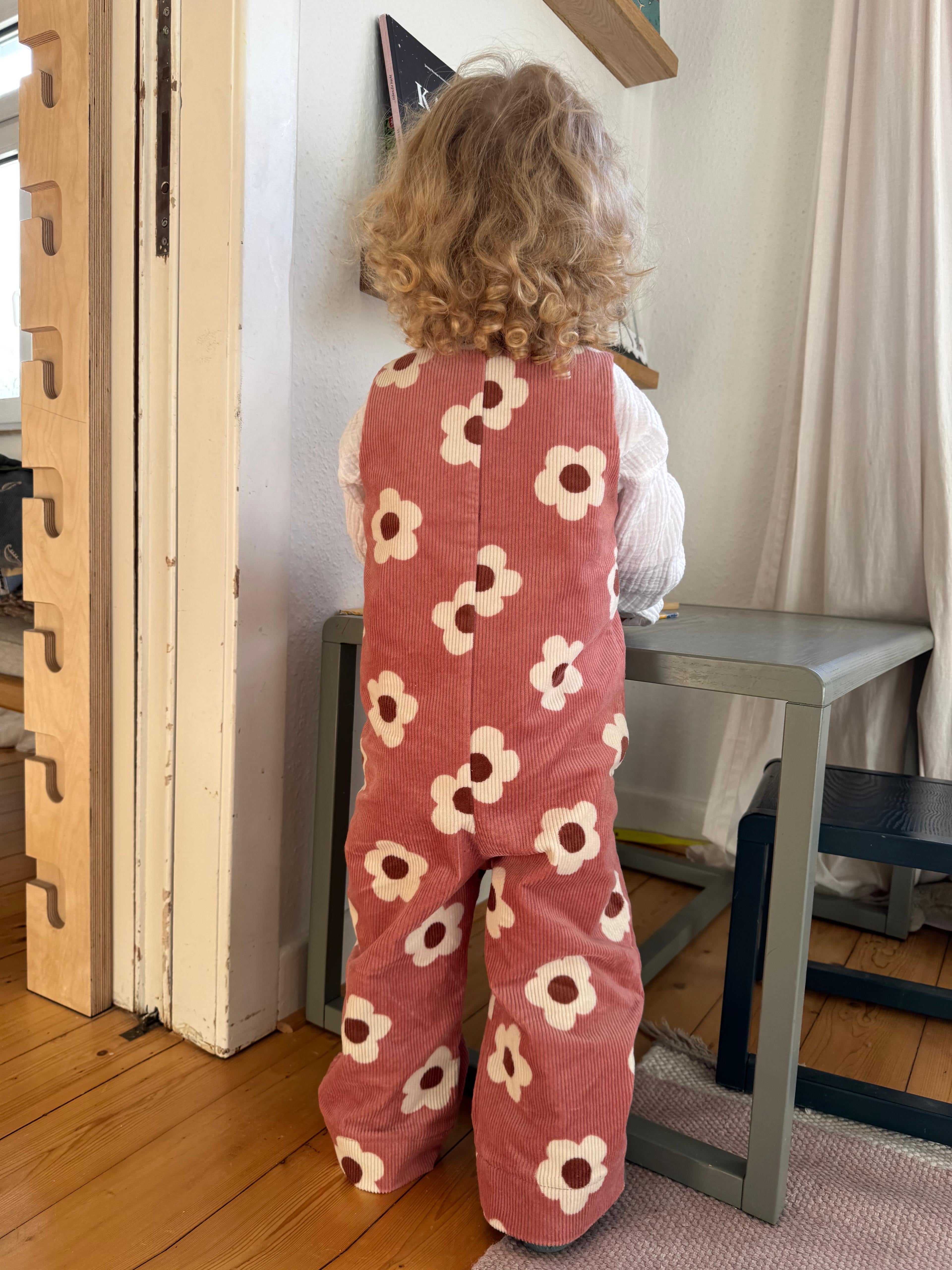 Baby Overall und Strampler mit rosa Blumen am Model, Rueckseite