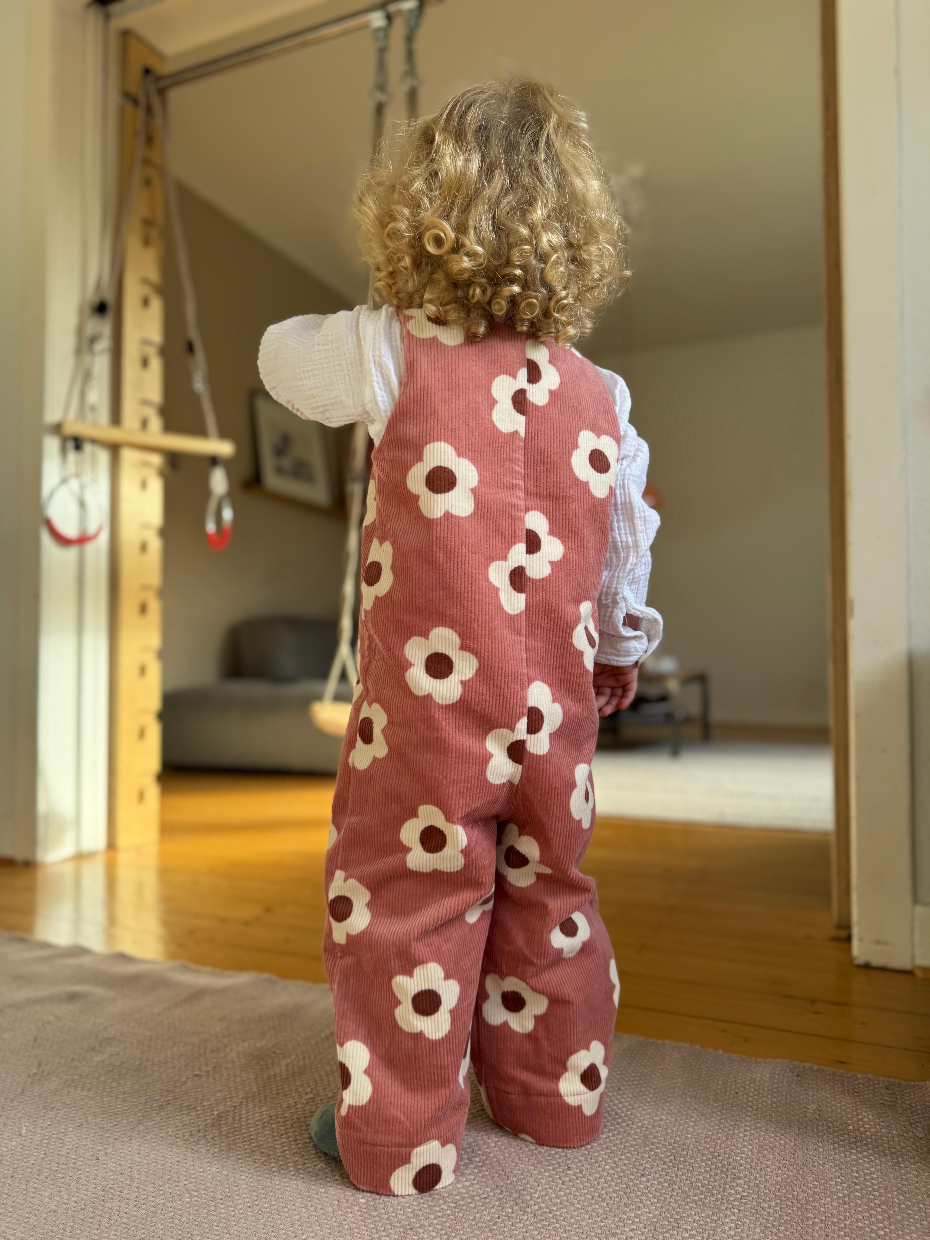 Baby Overall und Strample rmit rosa Blumen am Model, Rueckseite