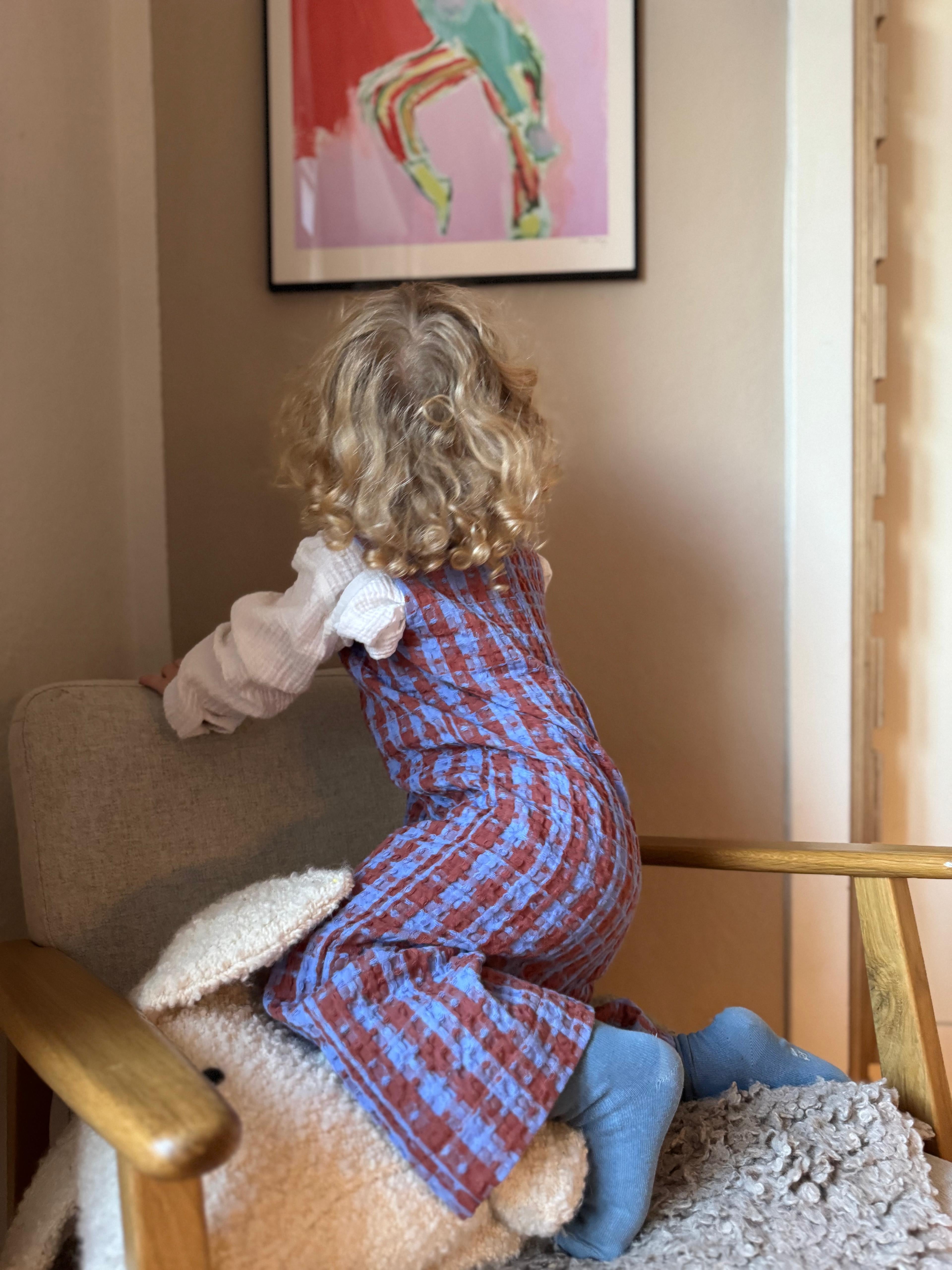 Kamping Studios Baby Overall und Strampler aus Baumwolle, kariert blau/rot am Model, Rueckseite