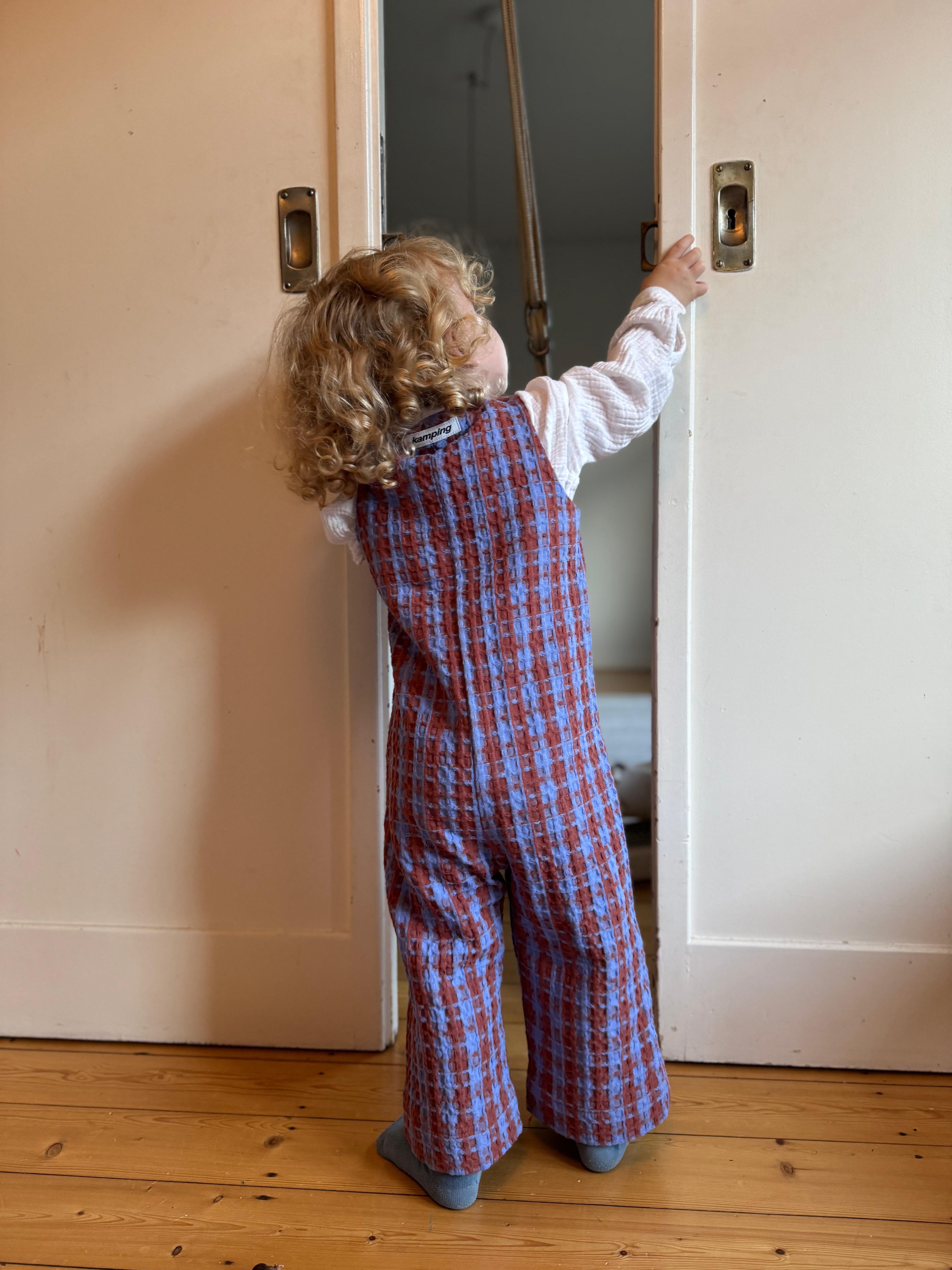 Kamping Studios Baby Overall und Strampler aus Baumwolle, kariert blau/rot, am Model, Rueckseite