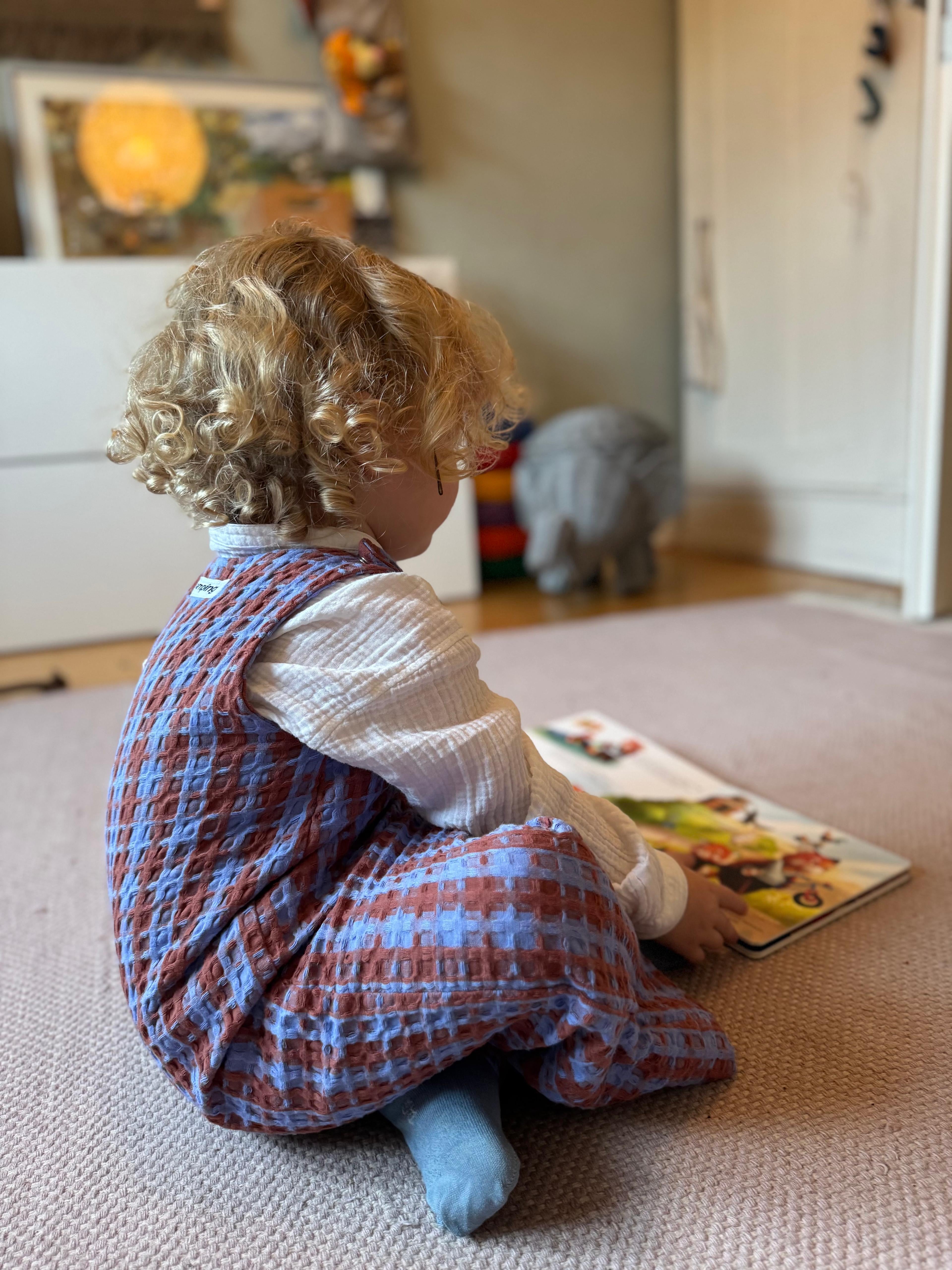 Kamping Studios Baby Overall und Strampler aus Baumwolle, kariert blau/rot, am Model, Seite