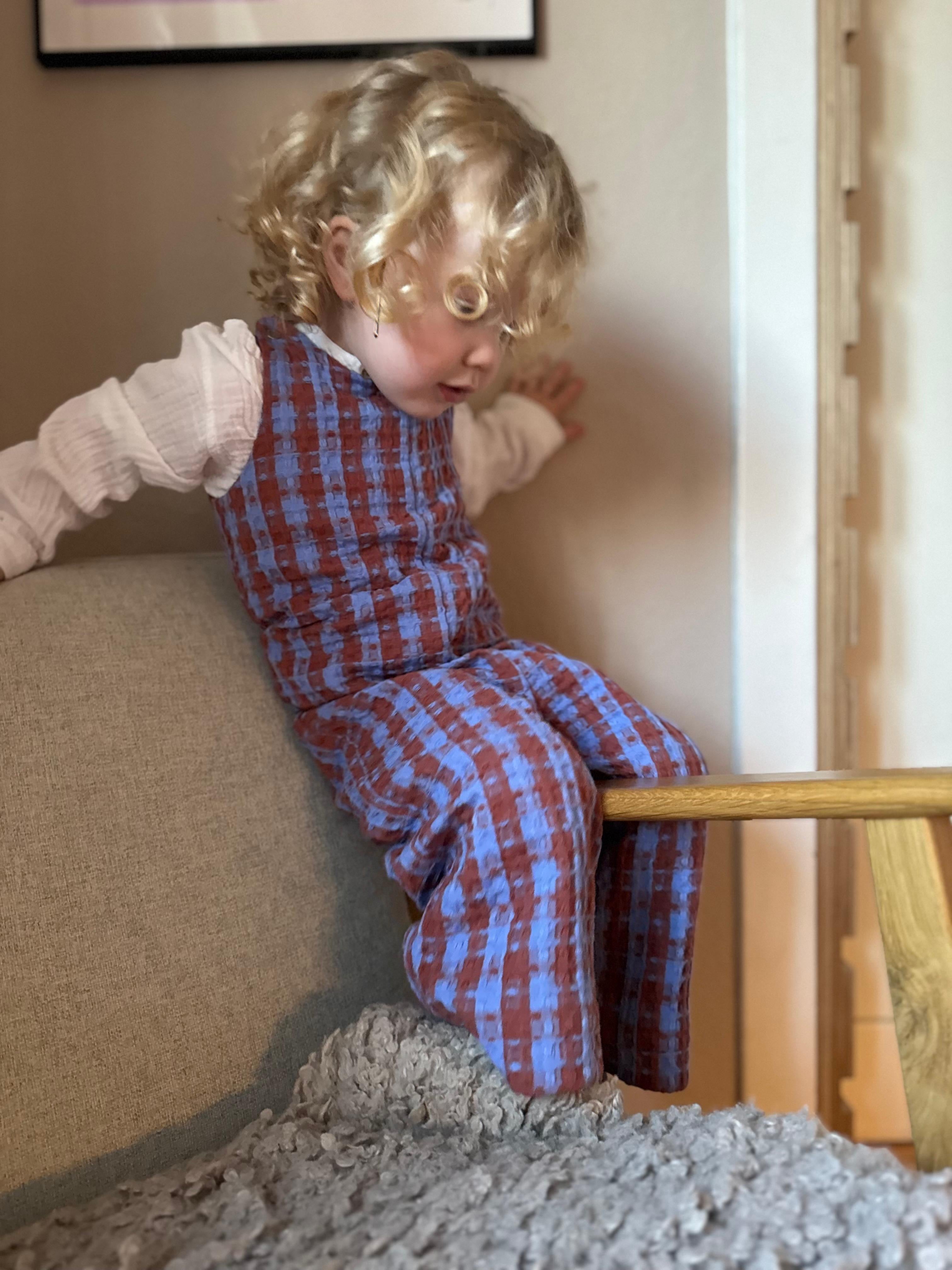 Kamping Studios Baby Overall und Strampler aus Baumwolle, kariert blau/rot, am Model, Vorderansicht