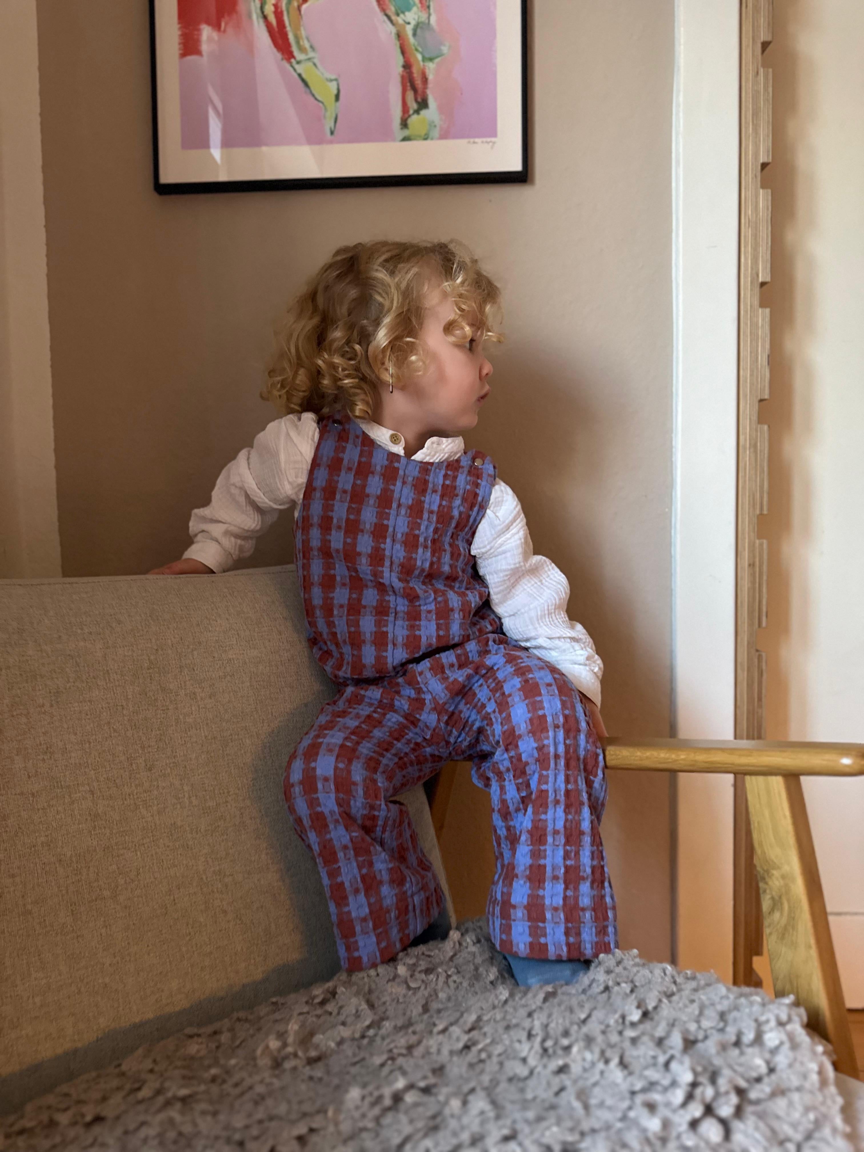 Kamping Studios Baby Overall und Strampler aus Baumwolle, kariert blau/rot, am Model, Vorderseite 