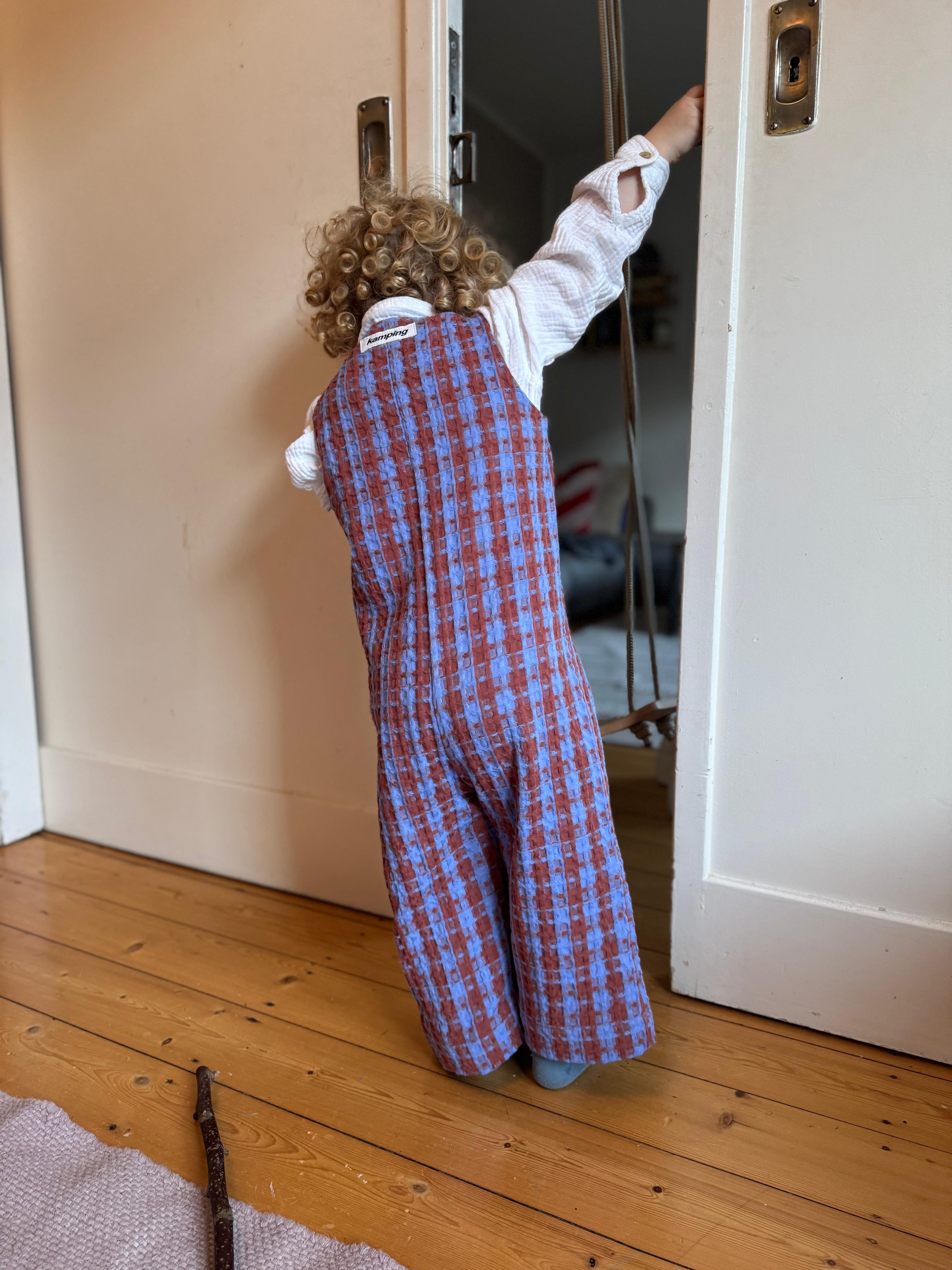 Kamping Studios Baby Overall und Strampler aus Baumwolle, kariert blau/rot, am Model, Rueckseite 3