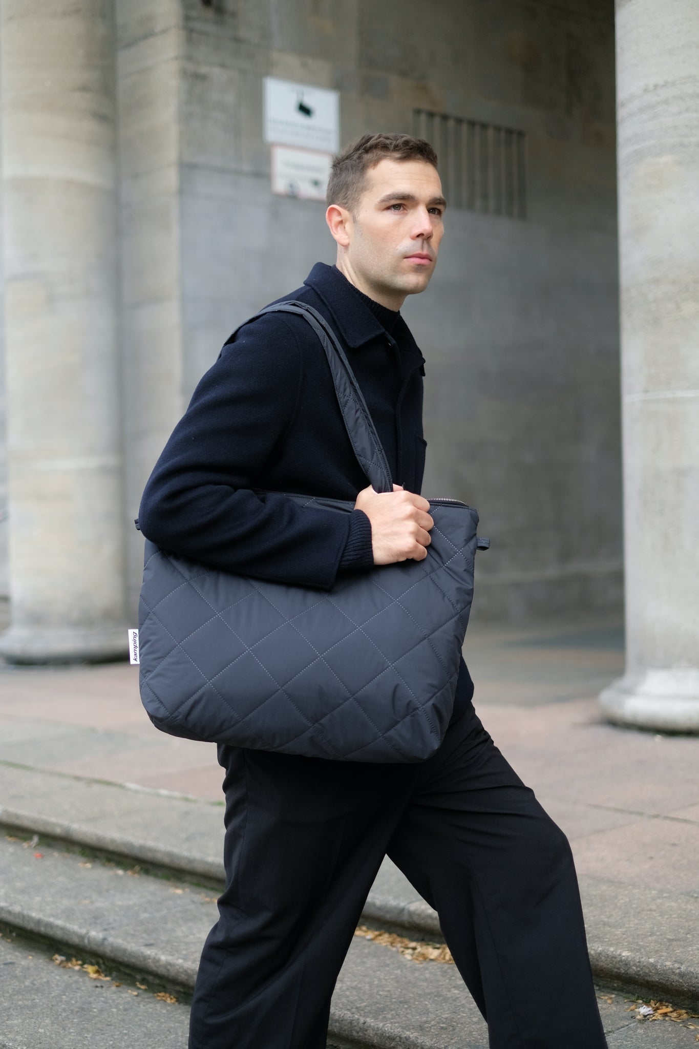 Kamping Studios Shopper schwarz, am maennlichen Model ueber Schulter