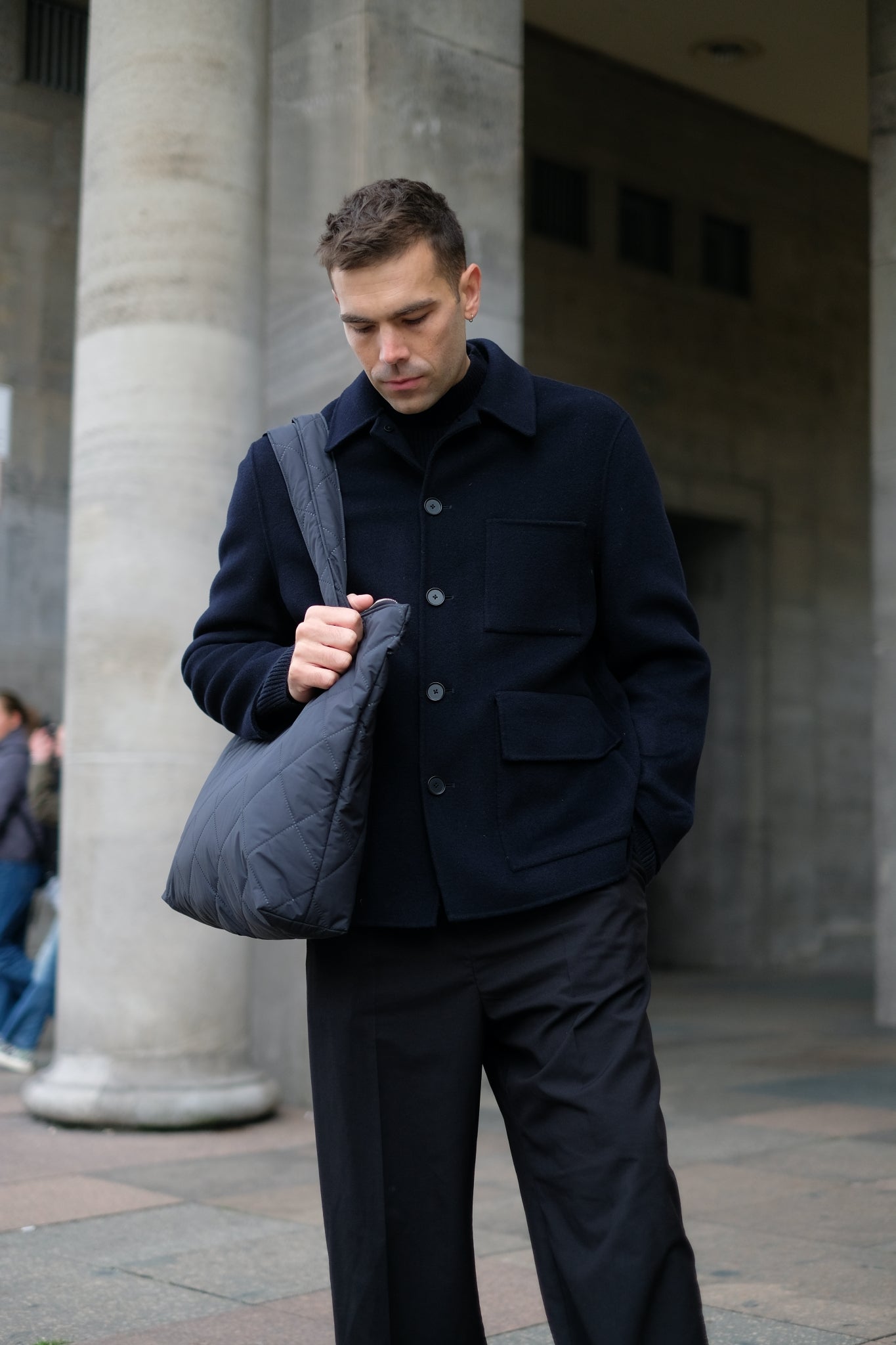 Kamping Studios Shopper schwarz, am maennlichen Model ueber Schulter