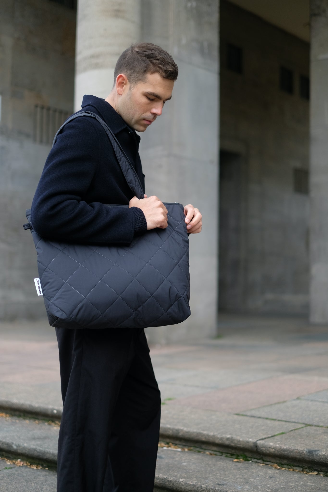 Kamping Studios Shopper schwarz, am maennlichen Model ueber Schulter 3
