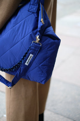 Kamping Studios Shopper in blau, am Model mit Schultergurt und Kette, Detail